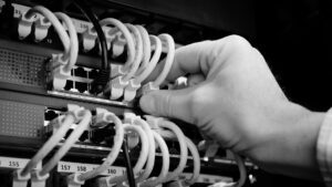 Mans hand testing cables for a network infrastructure