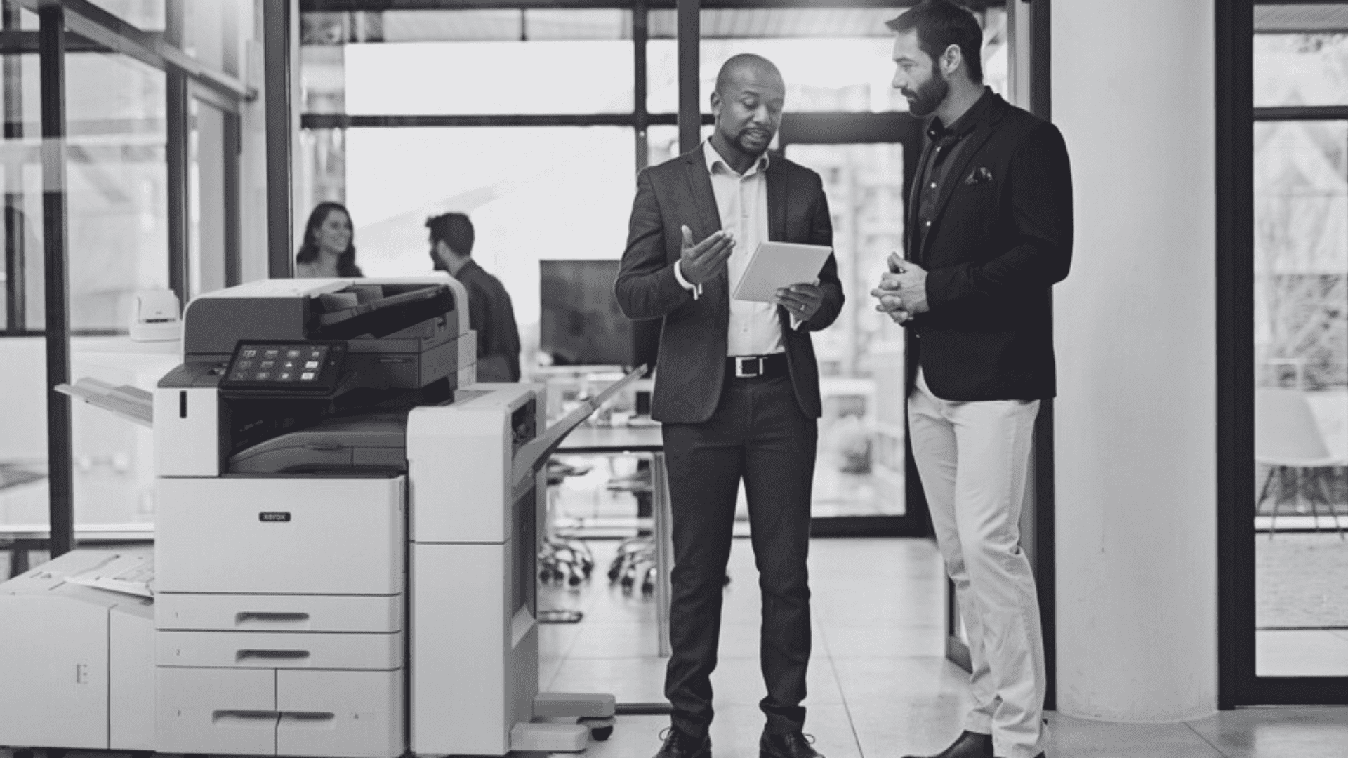 Two men standing by Xerox AltaLink printer in an office